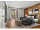 Bright bedroom featuring wood-paneled wall, balcony access, and soft neutral tones at 3662 S Granby Way # J05, Aurora, CO 80014