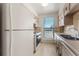 Compact kitchen featuring essential appliances and a bright window at 3662 S Granby Way # J05, Aurora, CO 80014