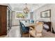Elegant dining room with tray ceilings, hardwood floors, and a large window providing natural light at 6338 Spotted Fawn Run, Littleton, CO 80125