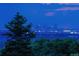 Distant view of the city skyline at dusk through the trees providing an urban backdrop at 6338 Spotted Fawn Run, Littleton, CO 80125