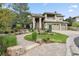 Stucco home with solar panels, 3-car garage, stone walkway and landscaped yard with mature trees at 6338 Spotted Fawn Run, Littleton, CO 80125