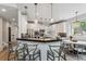 Kitchen featuring a breakfast bar with seating, stainless steel appliances, and contemporary lighting fixtures at 6338 Spotted Fawn Run, Littleton, CO 80125