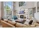 Bright living room with high ceilings, fireplace, built-in shelves, and large windows with views to the outside at 6338 Spotted Fawn Run, Littleton, CO 80125