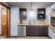 Finished basement wet bar with dark cabinetry, mini fridge, and modern sink at 7202 Snow Peak Ct, Niwot, CO 80503