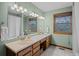 Bathroom featuring double sinks, a large mirror, and wooden cabinetry at 7202 Snow Peak Ct, Niwot, CO 80503