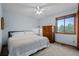 Bedroom features a bright window, a ceiling fan, and soft neutral colored carpet at 7202 Snow Peak Ct, Niwot, CO 80503