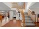 Grand foyer features a staircase, wood and carpet flooring, coat rack, and open access to other living areas at 7202 Snow Peak Ct, Niwot, CO 80503