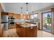 Bright kitchen features stainless appliances, wood cabinets, granite counters, and a large center island with cooktop at 7202 Snow Peak Ct, Niwot, CO 80503