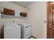 Practical laundry room features a washer, dryer, shelving, and access door to another area in the house at 7202 Snow Peak Ct, Niwot, CO 80503