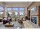 Cozy living room features a brick fireplace, large windows, and hardwood floors, perfect for creating a welcoming atmosphere at 7202 Snow Peak Ct, Niwot, CO 80503