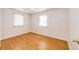 Bright bedroom featuring clean white walls, a pair of windows, and light wood-look laminate flooring at 3125 W Ford Pl, Denver, CO 80219
