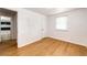 Bedroom with neutral walls and wood-look flooring, plus a bathroom visible through the doorway at 3125 W Ford Pl, Denver, CO 80219