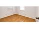 Bright bedroom featuring clean white walls, a window, light wood-look laminate flooring, and built-in shelves at 3125 W Ford Pl, Denver, CO 80219