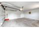 A clean, empty garage with an open door and an included snow shovel at 3125 W Ford Pl, Denver, CO 80219