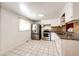 Bright kitchen with tile floor, stainless steel appliances, and ample cabinet space at 3125 W Ford Pl, Denver, CO 80219