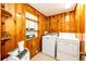 Charming laundry room featuring wood paneling, shelving, and convenient washer and dryer at 3125 W Ford Pl, Denver, CO 80219