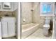 Tiled bathroom with tub, shower, toilet and vanity with white cabinets at 1270 Havana St, Aurora, CO 80010