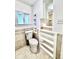 Well-lit bathroom featuring a toilet, window, and built-in shelving for ample storage at 1270 Havana St, Aurora, CO 80010