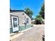 View of exterior with back entrance, gravel parking, and green trim on siding at 1270 Havana St, Aurora, CO 80010