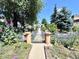Charming vintage-style home's address on a front gate along a vibrant garden path with flowers at 1270 Havana St, Aurora, CO 80010