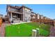 Fenced backyard featuring artificial turf, a putting green, and a covered porch at 718 176Th Ave, Broomfield, CO 80023