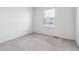 An empty bedroom with neutral carpet and walls and a bright window at 718 176Th Ave, Broomfield, CO 80023