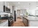 Contemporary kitchen features stainless steel appliances, granite counters, ample cabinet space, and wood flooring at 718 176Th Ave, Broomfield, CO 80023