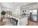 Modern kitchen features a large granite island, stainless steel appliances, gray cabinets, and wood flooring with barstool seating at 718 176Th Ave, Broomfield, CO 80023