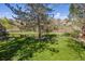 Beautiful backyard featuring a lush lawn, mature trees, and a wooden fence at 6336 S Newland Ct, Littleton, CO 80123