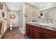 Bright bathroom features a dual sink vanity, a mosaic backsplash, and a walk-in shower at 6336 S Newland Ct, Littleton, CO 80123