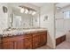 Bathroom featuring a dual sink vanity with tile countertops and plenty of cabinet space at 6336 S Newland Ct, Littleton, CO 80123