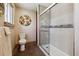 Bathroom featuring a tiled shower, toilet, mosaic backsplash and unique modern decorations at 6336 S Newland Ct, Littleton, CO 80123