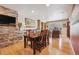 Dining room with hardwood floors, a large table, and a stone accent wall at 6336 S Newland Ct, Littleton, CO 80123