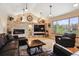 Comfortable living room with stone fireplace, vaulted ceilings, and abundant natural light at 6336 S Newland Ct, Littleton, CO 80123