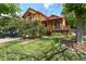 Charming two-story home featuring vibrant yellow siding, red trim, mature landscaping, and a quaint front porch at 3201 W 126Th Ave, Broomfield, CO 80020