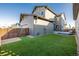 Back exterior with artificial grass, gray vinyl siding and modern architecture and a spacious, well-maintained lawn at 1365 W 67Th Pl, Denver, CO 80221