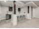 Finished basement showcasing bar with barstool seating, and stainless steel beverage cooler at 1365 W 67Th Pl, Denver, CO 80221