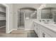 Modern bathroom features a glass-enclosed shower, double sink vanity, and stylish gray and white decor at 1365 W 67Th Pl, Denver, CO 80221