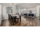 Open-concept dining room featuring hardwood floors, modern lighting, and a view into the living area at 1365 W 67Th Pl, Denver, CO 80221