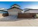 Exterior of home showcasing modern gray siding, a two-car garage, and a concrete driveway on a clear day at 1365 W 67Th Pl, Denver, CO 80221