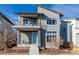 Two-story home featuring a gray exterior, balcony with metal railing, and a bright blue front door at 1365 W 67Th Pl, Denver, CO 80221