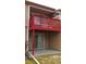View of the townhouse featuring a bright red balcony and a sliding glass door leading to an outdoor patio at 7490 W Coal Mine Ave # A, Littleton, CO 80123