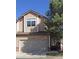 Tan two-story townhome with a two car garage, set against a clear blue sky at 7490 W Coal Mine Ave # A, Littleton, CO 80123