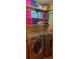Well-organized laundry room featuring front loading washer and dryer and colorful storage units on shelves at 7490 W Coal Mine Ave # A, Littleton, CO 80123