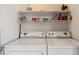 A tidy laundry room with a side-by-side washer and dryer, and an overhead shelf for supplies at 8199 Welby Rd # 3707, Denver, CO 80229