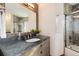 Bathroom featuring granite counter with sink and tile accents and tile shower with glass door at 100 Balsam St, Lakewood, CO 80226