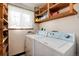 Functional laundry area with shelving and side-by-side washer and dryer at 100 Balsam St, Lakewood, CO 80226