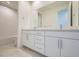 Bright bathroom showcasing double sinks, vanity, ample counter space, and a soaking tub for modern living at 682 Belay St, Erie, CO 80516