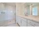 Modern bathroom featuring a glass-enclosed shower, marble countertop, sleek cabinets and double shower head at 682 Belay St, Erie, CO 80516