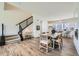 Open-concept dining area with staircase, wood floors, natural light, and modern table setting for entertaining at 682 Belay St, Erie, CO 80516